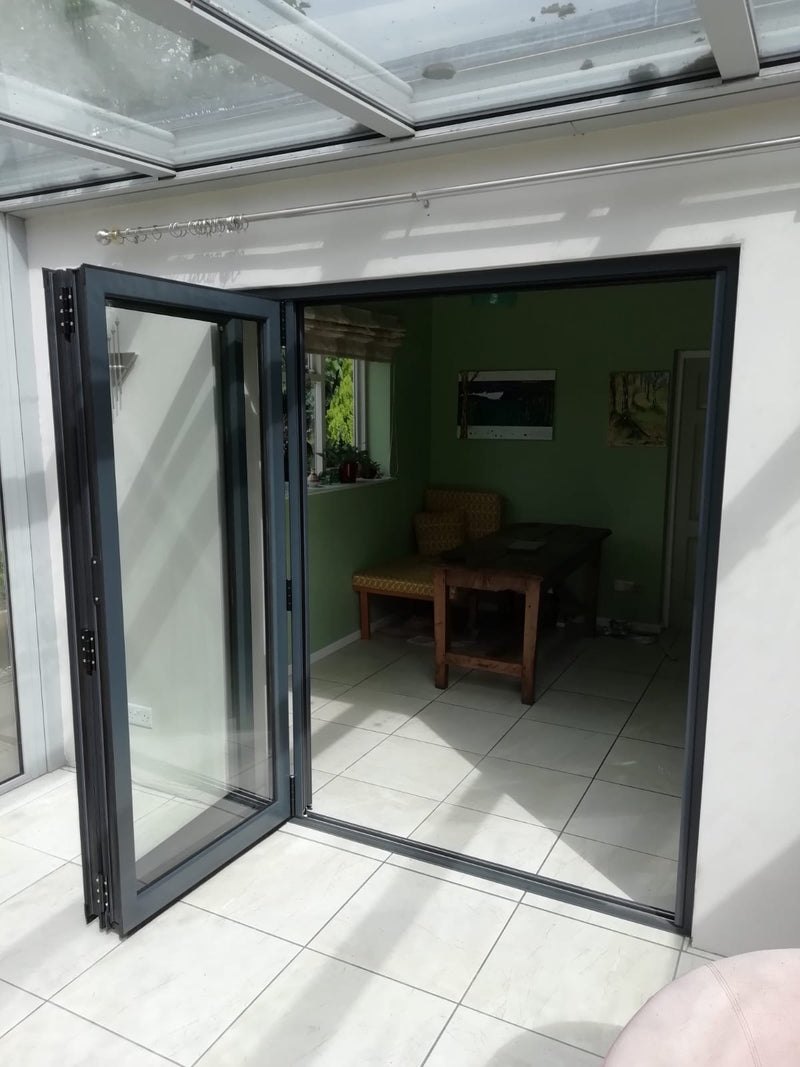 Open glass door leading to a room with furniture and decor.