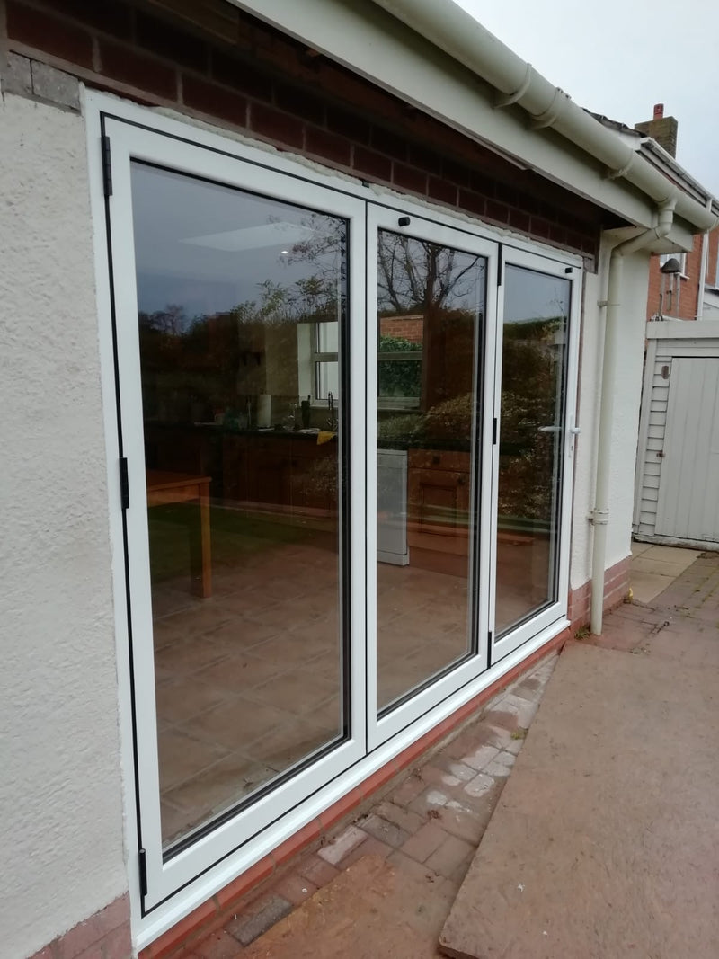 Set of sliding glass doors on a house exterior with a view of a garden.