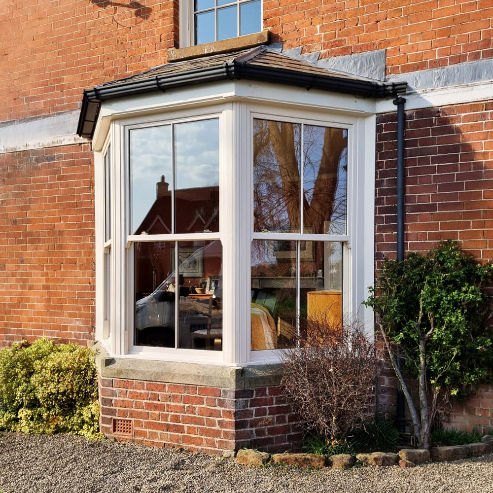 Bay window of a brick building with reflections in the glass